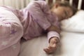 Cute cheerful little 3-4 years preschool baby girl kid sleeping sweetly in white crib during lunch rest time in pink Royalty Free Stock Photo