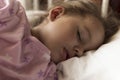 Cute cheerful little 3-4 years preschool baby girl kid sleeping sweetly in white crib during lunch rest time in pink Royalty Free Stock Photo