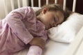 Cute cheerful little 3-4 years preschool baby girl kid sleeping sweetly in white crib during lunch rest time in pink Royalty Free Stock Photo