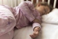 Cute cheerful little 3-4 years preschool baby girl kid sleeping sweetly in white crib during lunch rest time in pink Royalty Free Stock Photo