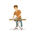 Cute cheerful man cutting wooden plank with a saw