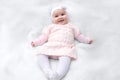Cute cheerful newborn dressed in pink shirt dress on white fur blanket. Adorable infant baby with headband Royalty Free Stock Photo