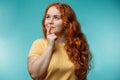 Cute cheerful redhead young girl over blue background with wondering face. Royalty Free Stock Photo