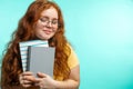 Cute cheerful redhead young girl in yellow over blue background with face. Royalty Free Stock Photo