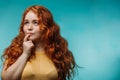 Cute cheerful redhead young girl in yellow t-shirt over blue background with funny face. Royalty Free Stock Photo