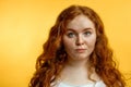 Cute cheerful redhead young girl in yellow t-shirt over blue background with funny face. Royalty Free Stock Photo