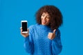 Cute and cheerful, satisfied african-american woman showing something on display, make thumb-up gesture, looking Royalty Free Stock Photo