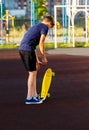 Cute cheerful smiling Boy in blue t shirt sneakers riding on yellow skateboard. Active urban lifestyle of youth, training, hobby Royalty Free Stock Photo