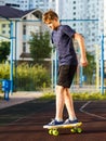 Cute cheerful smiling Boy in blue t shirt sneakers riding on yellow skateboard. Active urban lifestyle of youth, training, hobby, Royalty Free Stock Photo