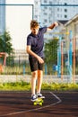 Cute cheerful smiling Boy in blue t shirt sneakers riding on yellow skateboard. Active urban lifestyle of youth, training, hobby Royalty Free Stock Photo