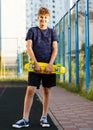 Cute cheerful smiling Boy in blue t shirt sneakers riding on yellow skateboard. Active urban lifestyle of youth, training, hobby