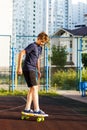 Cute cheerful smiling Boy in blue t shirt sneakers riding on yellow skateboard. Active urban lifestyle of youth, training, hobby Royalty Free Stock Photo