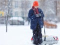 Cute, cheerful young boy in hat, blue jacket plays with snow, has fun, smiles, makes snowman in winter park. Royalty Free Stock Photo