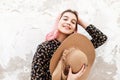 Cute cheerful young woman with sweet smile in fashionable clothes straightens pink beautiful hair. Positive smiling girl model in Royalty Free Stock Photo