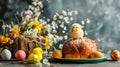 Cute chick on top of the Easter kulich on the table surrounded by eggs and flowers Royalty Free Stock Photo