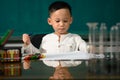 Cute child Asian boy doing homework. Clever kid drawing at desk. Schoolboy. Elementary school student drawing at workplace. Kid Royalty Free Stock Photo