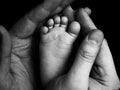 Cute child baby babe little foot in the father hands. Classical closeup shot about family values and parents child children love.