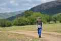 Cute child boy with backpack walking on a little path in mountains. Hiking kid Royalty Free Stock Photo