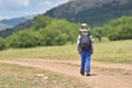 Cute child boy with backpack walking on a little path in mountains. Hiking kid Royalty Free Stock Photo