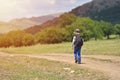 Cute child boy with backpack walking on a little path in mountains. Hiking kid Royalty Free Stock Photo