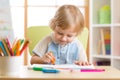 Cute child boy is drawing with felt-tip pen in preschool Royalty Free Stock Photo