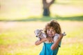 Cute child boy feels delighted, carries little puppy dog, expresses tender emotions, care and love to small doggy Royalty Free Stock Photo