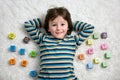 Cute child, boy, play with toy blocks, lying on the floor Royalty Free Stock Photo