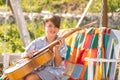 Cute child boy playing guitar on nature background. Kids music and songs. Smiling child playing outdoors in summer. Royalty Free Stock Photo