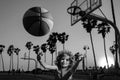 Cute child boy plays basketball. Active kids enjoying outdoor game with basketball ball on Venice beach basketball court Royalty Free Stock Photo