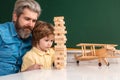 Cute child boy with teacher playing in classroom near blackboard desk. Private kids tutoring. Home school for pupil