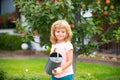 Cute child boy with watering can in the yard garden. Adorable little child helping parents to grow vegetables Royalty Free Stock Photo