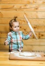 Cute child cooking with dough, flour and wood rolling pin