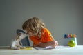 Cute child and dog playing at home. Back to school. A Cute little boy with pet puppy doing homework.