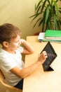 Cute child doing homework with tablet at home Royalty Free Stock Photo