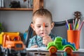 Cute child is drawing with pencils on paper in an album at the table. Preschool education and development of creativity Royalty Free Stock Photo