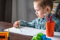 Cute child is drawing with pencils on paper in an album at the table. Preschool education and development of creativity Royalty Free Stock Photo