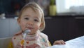 Cute child eating. Baby girl eating healthy food herself. Royalty Free Stock Photo