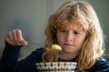 Cute child eating breakfast at home. Sad boy eating healthy chicken noodle soup for lunch. Unhappy baby child taking Royalty Free Stock Photo