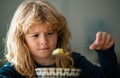 Cute child eating breakfast at home. Sad boy eating healthy chicken noodle soup for lunch. Unhappy baby child taking Royalty Free Stock Photo