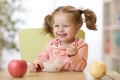 Child eating healthy food with the left hand at home