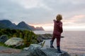 Cute child, enjoying amazing view from a rock in Husoy on Senja island, North Norway. Amazing beautiful landscape and splendid