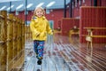 Cute child, enjoying little fishing village with rorbuer cabins on a heavy rainy day