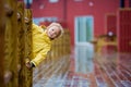 Cute child, enjoying little fishing village with rorbuer cabins on a heavy rainy day