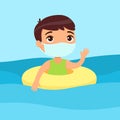 Cute child with a face mask having fun in water, waving hand.