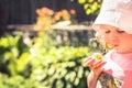 Cute child girl blowing soap bubble in summer park in sunny day with sunlight