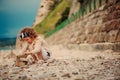 Cute child girl building stone tower on the beach Royalty Free Stock Photo