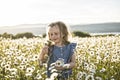 Cute child girl at camomile field daisy