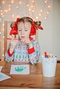 Cute child girl in Christmas sweater making handprints postcard Royalty Free Stock Photo