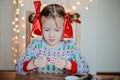 Cute child girl in christmas sweater making post cards Royalty Free Stock Photo