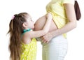 Cute child girl embracing pregnant mother belly